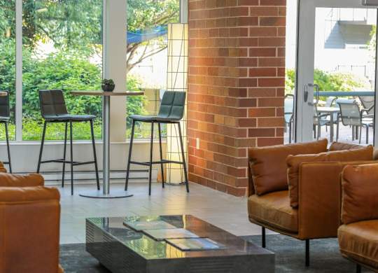 A room with a glass table and leather chairs.