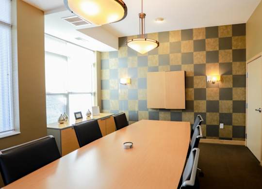 A conference room with a long table and chairs.