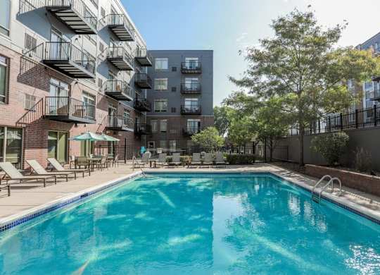 A swimming pool in a residential area surrounded by buildings.