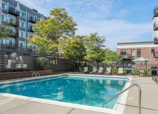 A swimming pool surrounded by trees and buildings.