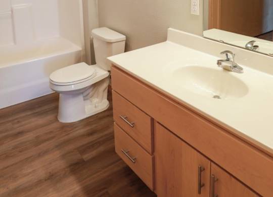 A white toilet sits next to a bathtub in a bathroom.
