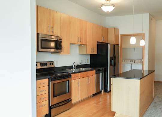A kitchen with wooden cabinets and black appliances.