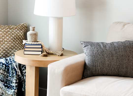 a side table with a lamp and books on it