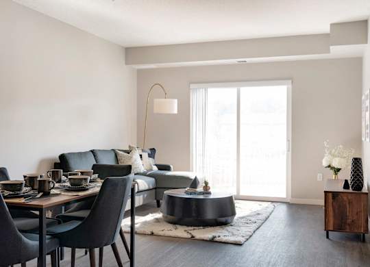 A modern dining room with a black table and chairs.