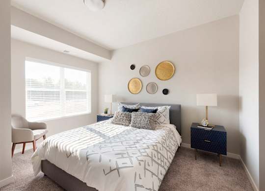 A bedroom with a bed, chair, and wall decor.