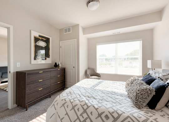 A bedroom with a large bed and a dresser.