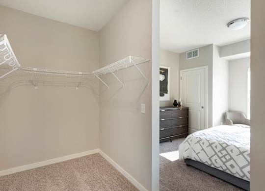 A bedroom with a white bed and a white closet.