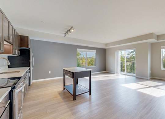 A spacious kitchen and dining area with wooden floors and large windows.