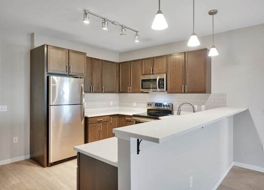 A kitchen with a white counter and wooden cabinets.