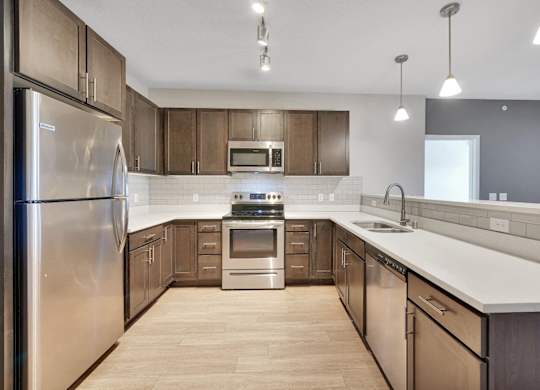 A modern kitchen with wooden cabinets and stainless steel appliances.