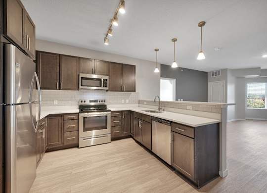 A modern kitchen with stainless steel appliances and wooden cabinets.