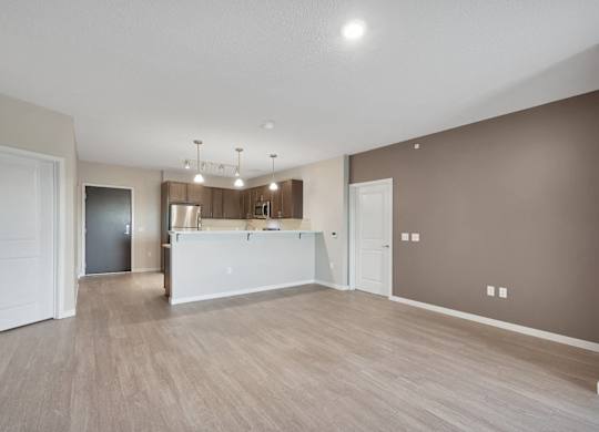 A spacious room with a white reception desk and a brown wall.