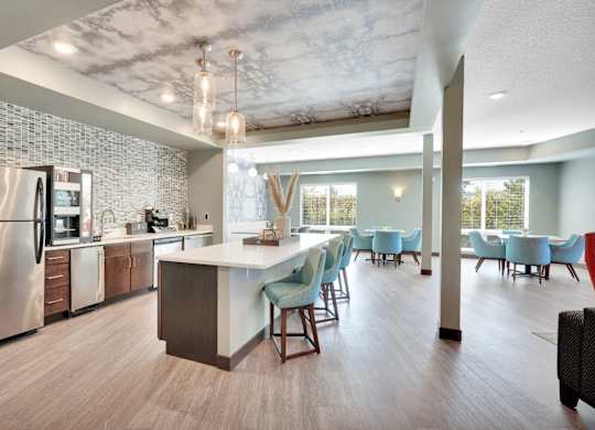A modern kitchen with a dining area and a refrigerator.