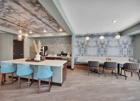 A kitchen with a bar area and blue chairs.