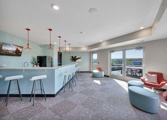 A modern bar area with a long counter and stools.