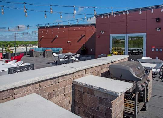 A red building with a grill on the patio.
