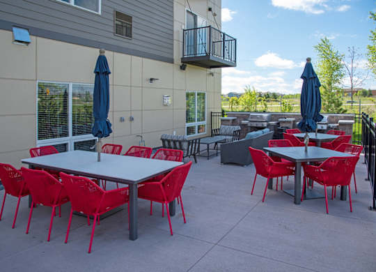 A patio with red chairs and tables.