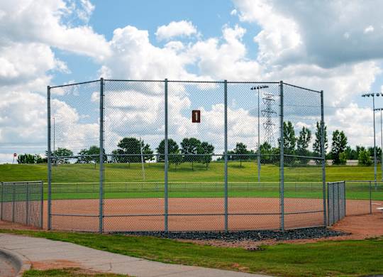 A baseball field is enclosed by a chain link fence.
