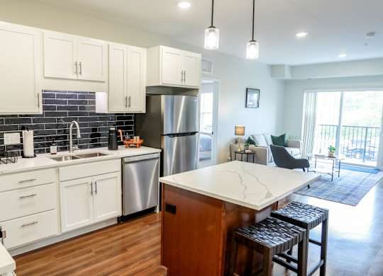 A kitchen with white cabinets and a wooden island.