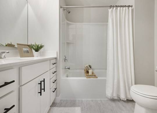 A white bathroom with a toilet, sink, and bathtub.