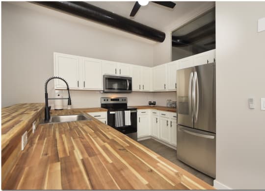 a kitchen with wood flooring and stainless steel appliances