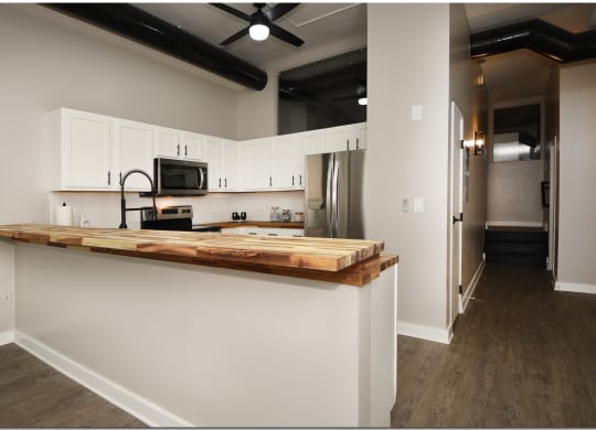 a kitchen with white cabinets and a wooden counter top