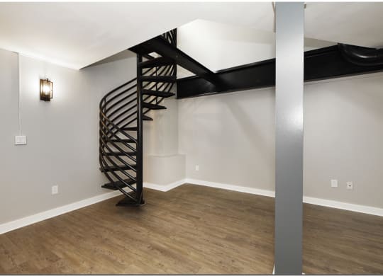 the living room has a spiral staircase leading to the loft