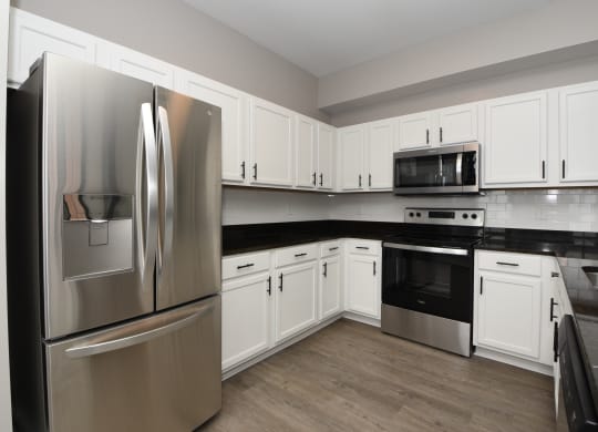 a kitchen with stainless steel appliances and white cabinets