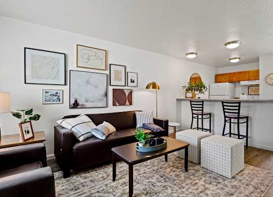 A living room with a brown couch, a coffee table, and a striped pillow. at Vivo Toledo Apartments, Toledo, OH, 43607