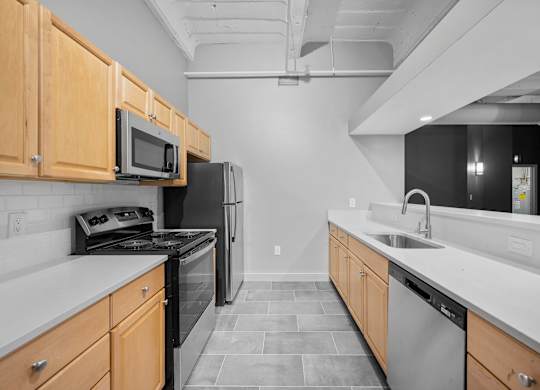 A kitchen with black appliances and wooden cabinets.