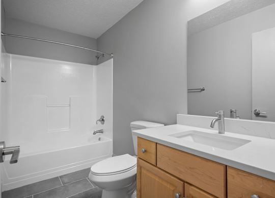 A white toilet sits next to a white sink in a bathroom.