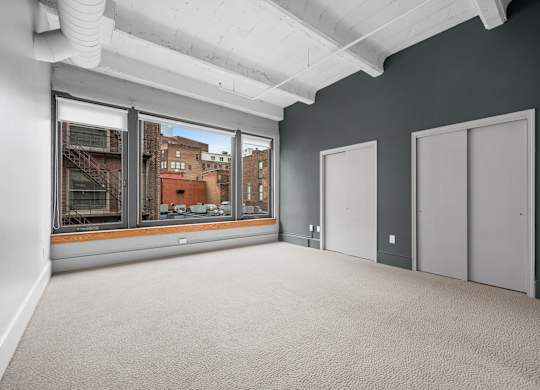 A room with a view of the city through large windows.