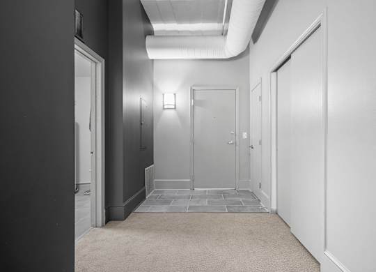 A hallway with doors on both sides and a carpeted floor.