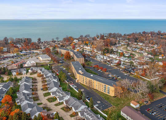 A view of a residential area with apartment buildings and a parking lot.
