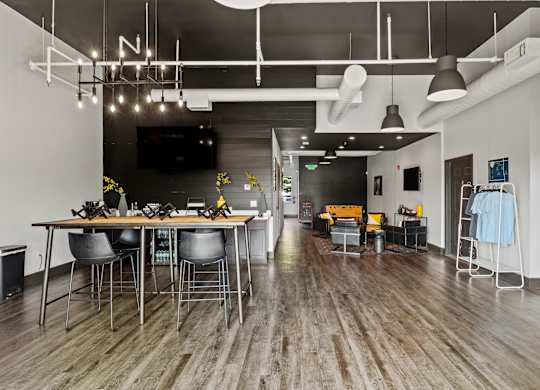 A modern dining area with a long table and chairs. at Vivo Toledo Apartments, Toledo, Ohio