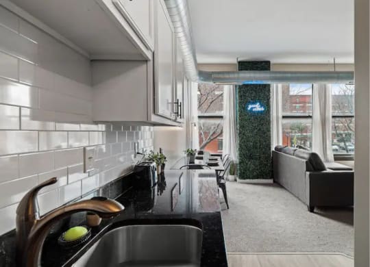 a kitchen and living room with a sink and a window