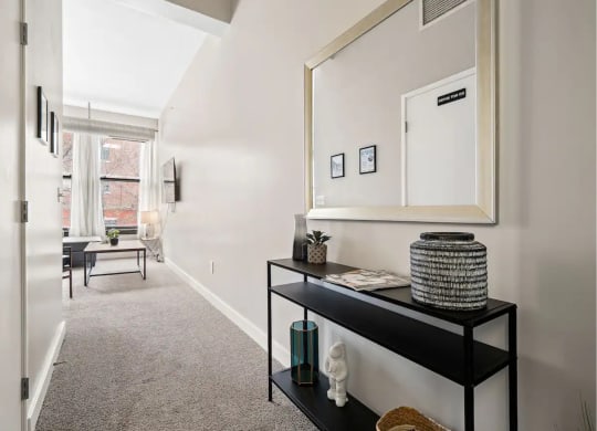 a hallway with a large mirror and a black shelf