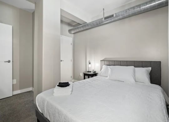 a white bedroom with a large bed and a white closet