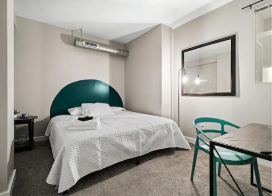 a bedroom with a bed and a table and chairs