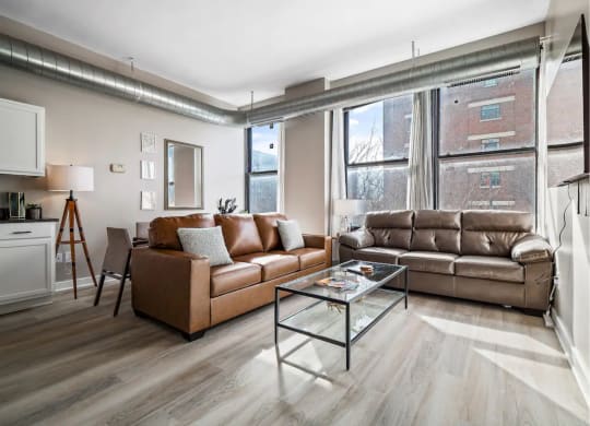a living room with leather couches and a glass coffee table