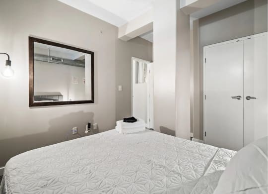 a bedroom with a large bed and a mirror
