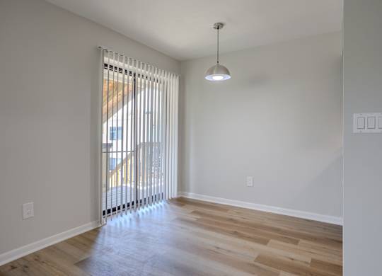 A room with a wooden floor and a window with blinds. at Commons At Waters Edge, Columbus Ohio