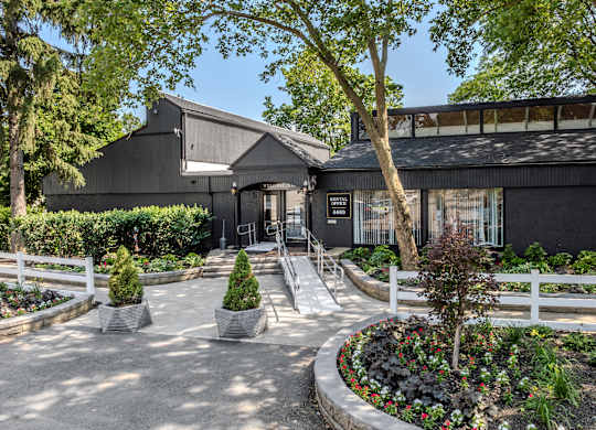A black building with a white fence and a garden in front. at Commons At Waters Edge, Columbus Ohio