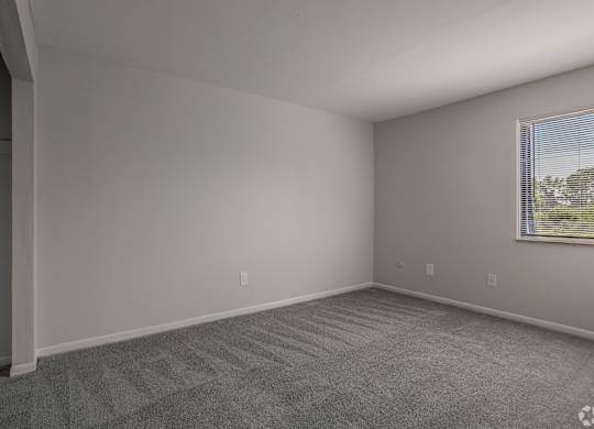 A room with a carpeted floor and a window with blinds at Commons At Waters Edge, Columbus Ohio