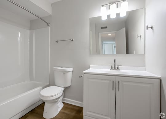 A white bathroom with a toilet, sink, and bathtub. at Commons At Waters Edge, Columbus Ohio