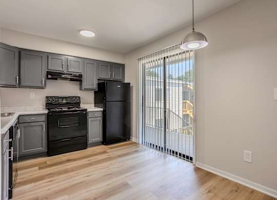 A kitchen with black appliances and wooden floors. at Commons At Waters Edge, Columbus Ohio