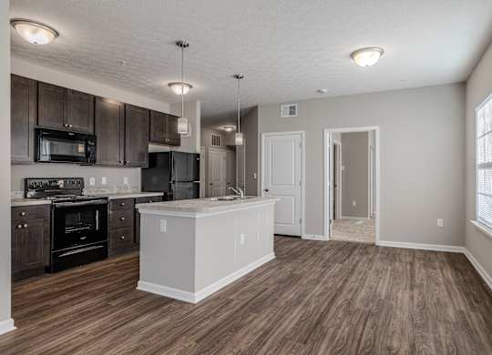 A kitchen with dark wood floors at The Residences at Akita Lane, Canal Winchester Ohio
