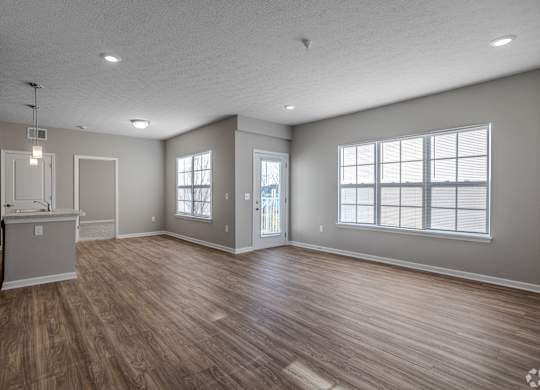 A spacious room with wood flooring and a kitchenette.at The Residences at Akita Lane, Canal Winchester