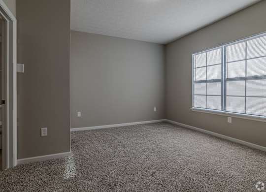 A room with a carpeted floor and a window with blinds.at The Residences at Akita Lane, Ohio