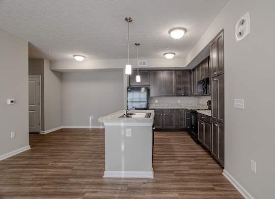A kitchen with a white island at The Residences at Akita Lane, Canal Winchester, OH 43110